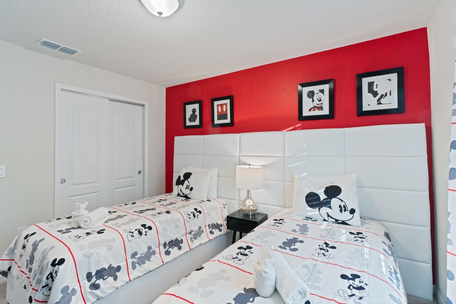 Mickey room with two twin beds, smart TV, and storage